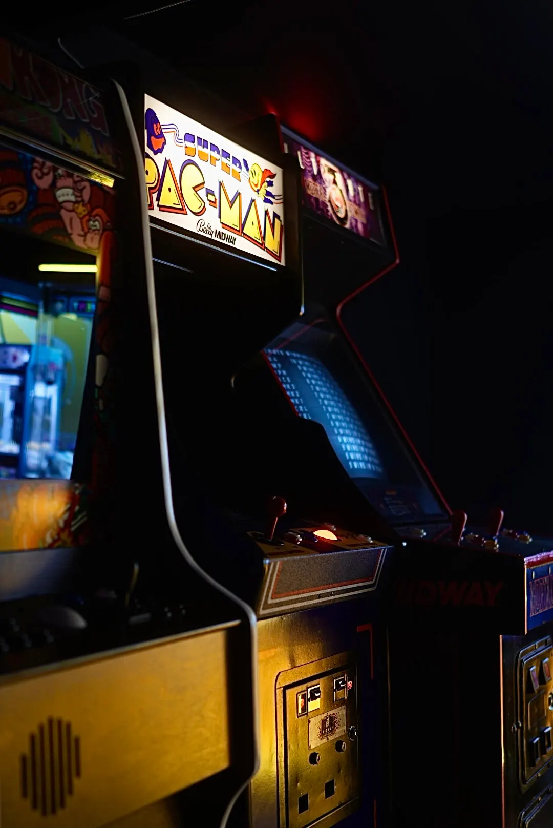 A lit Pac-Man cabinet in a row of retro arcade machines