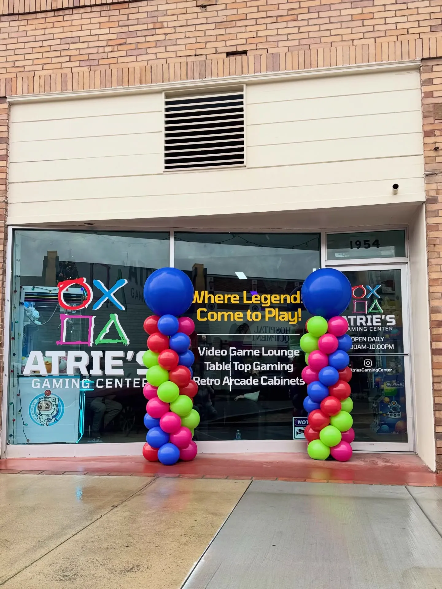 The Atrie's Gaming Center storefront on High Street, with the logo and Where Legends Come to Play painted on the windows and balloon columns by the door